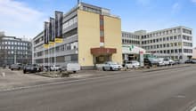 Office building with parking area, located near other buildings