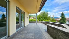 outdoor terrace with sliding glass doors, stone floor, stone railing, overlooking distant landscape
