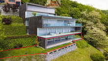Modern house with terrace and glass windows, built on a sloped area