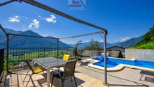 Balcony with pool, metal pergola, table, chairs, swings, view of mountains