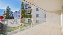 Terrace with glass railings, tiled floor, panoramic views of surrounding mountains and landscape