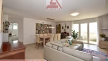 white leather sofa, dining table, glass doors, plants, rug, white walls, ceiling light