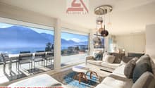 large windows, balcony, dining table, couch, coffee table, rug, chandelier