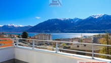 Building with balcony, overlooking mountains and lake