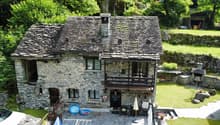 Stone house, wooden door, balcony, garden, green surroundings