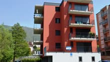 apartment building, red brick, multiple balconies, private parking