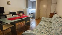 Table with 4 chairs, couch, microwave, refrigerator, flat screen TV, kitchen area