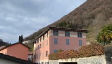 2 story building, multiple windows, garage, hilly surroundings
