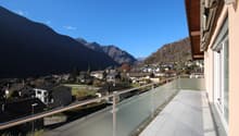 modern balcony with panoramic view of valley, glass railings, tiled floor