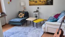 living room with two couches, coffee table, side table, rug, guitar, painting, lamp, radiator