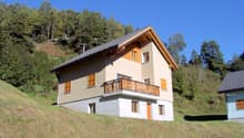2 story house, beige and wooden exterior, balcony, chimney, raised ground floor