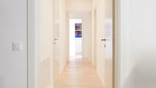corridor, white walls, white ceiling, hardwood floor, recessed ceiling lights