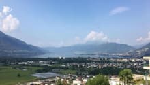 Aerial view of mountains, lake, and city.