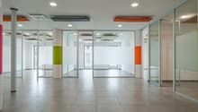 Wide hallway, tiled flooring, glass walls, no furniture visible