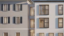 3 story modern apartment building, white exterior, multiple windows, surrounded by greenery, mountains in the background