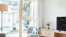 modern design, floor-to-ceiling windows, wooden floor, comfortable seating, neutral color palette, decorative vase, TV