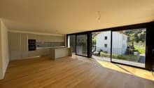Modern kitchen with countertops, wooden floors, glass sliding doors leading to balcony