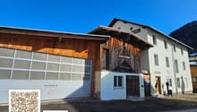 2-story building, white and wooden exterior, large garage, multiple windows, street-facing entrance