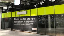 Yellow and green panels with a glass entrance and an advertising banner for 'coop'