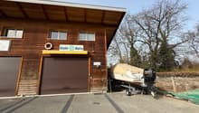 Wooden building with 2 garages, sign reading Nicolet Marine, boat with an outboard motor