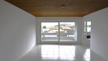 white tile floor, large windows with balcony, wooden ceiling, view of the town