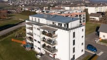 multi-story building with balconies on each floor, located in a suburban area