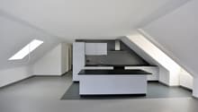 Empty kitchen with countertop, cabinets, sink, stove, and skylights