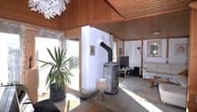 white leather couch, fireplace, wooden ceiling, large windows, potted plant, piano, lamp, rug, television