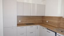 modern kitchen with white cabinets, wooden countertops, white drawers, a stove, and a sink
