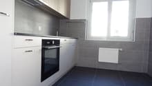 gray tile wall, blue tile floor, white cabinet, electric stove, window, radiator