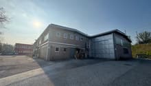 two story brick building, large garage, wide asphalt parking area