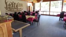 spacious dining area, wooden walls, glass windows, wooden tables and chairs, tiled floor, large windows offering outdoor views