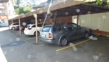 outdoor car park covered by a roof, cars parked