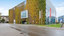 Modern glass and steel structure with a vertical garden covering a large section of the building.