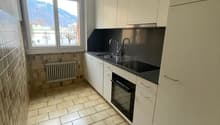 modern kitchen, tiled floor, white cabinets, black countertops, window with mountain view