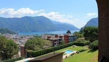 Building with a view of the city and mountains, swimming pool, and a lake