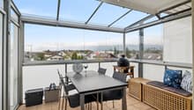 Ein lichtdurchfluteter, vollständig verglaster Balkon eröffnet einen freien Blick auf die eindrucksvolle Bergwelt.