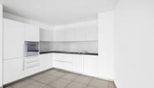 modern kitchen with white cabinets, black countertops, integrated oven, sink with faucet, tiled floor