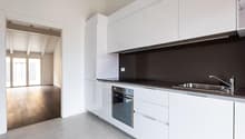 modern kitchen with white cabinets, gray tiled floor, stainless steel sink, oven, dishwasher, and a faucet