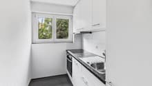 modern kitchen with white cabinets, black countertops, stainless steel sink, electric stove, oven, dishwasher, window
