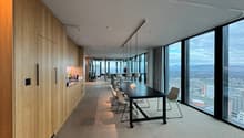 modern office space, with glass walls, white desks, beige carpet, wooden wall paneling, long conference table, office chairs, clear view