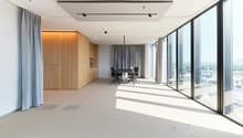 modern office room with wooden floor, large glass windows, table and chairs, wooden storage units, curtain