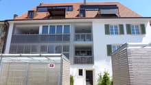 3 story white house, red roof, green shutters, balconies, entrance gate