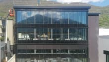 modern office building, glass facade, multiple floors, mountain view
