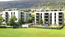 Two apartment buildings, modern architecture, large balconies, open green spaces, playground