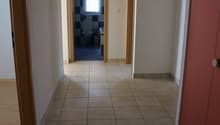 empty hallway, tiled floor, bathroom on the right