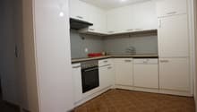modern kitchen with white cabinetry, dark countertops, oven, dishwasher, sink, faucet