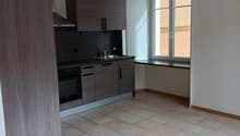 empty kitchen with tiled floor, wooden cabinets, black countertop, sink, oven, window