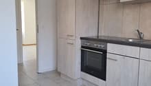modern kitchen with white tiled floor, wooden cabinets, stainless steel appliances, and a sink with a faucet