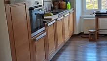 kitchen with wooden cabinets, oven, sink, window, wooden floor